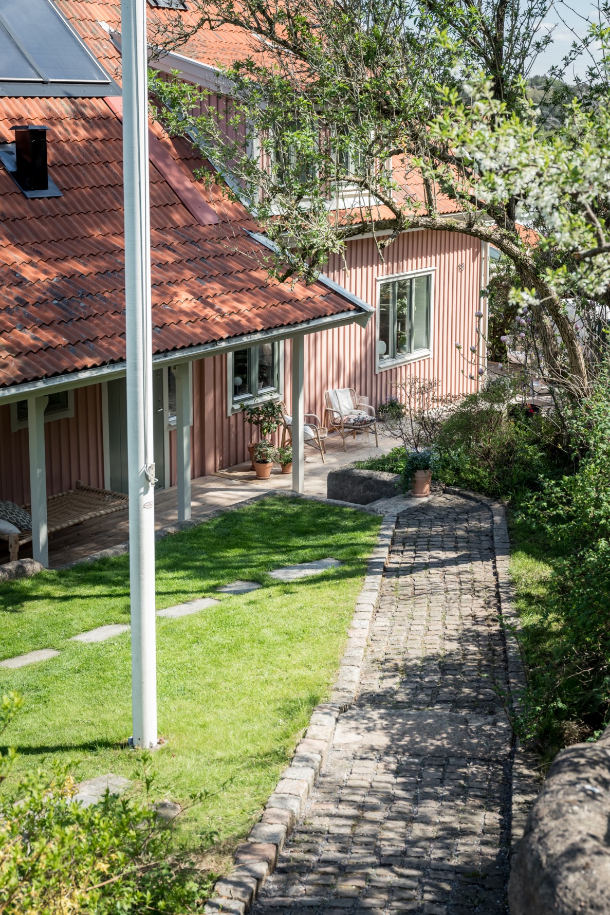 Trappor och en gång av kullersten leder ner till huset
